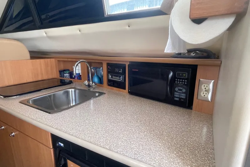 Slide: The Image of Compact kitchen area in a 2007 Bayliner Discovery 288, featuring a sink and microwave. - 9