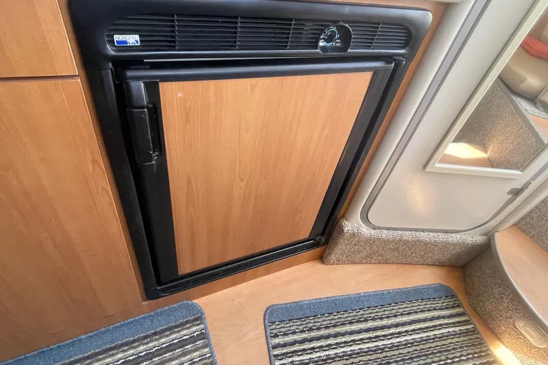 Slide: The Image of 2007 Bayliner Discovery 288 interior with Norcold refrigerator and wooden cabinetry. - 17