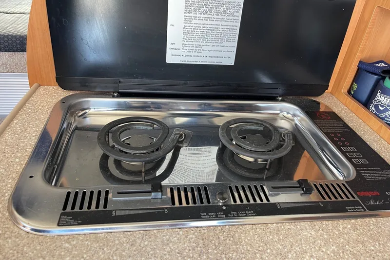 Slide: The Image of 2007 Bayliner Discovery 288 stove with two burners in a compact kitchen setup. - 21