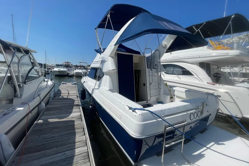 Slide: The Image of 2007 Bayliner Discovery 288 docked at marina, featuring blue canopy and white hull. - 29