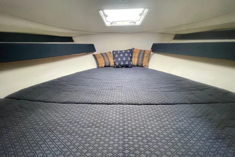 Slide: The Image of Cozy cabin interior of 2007 Bayliner Discovery 288 with nautical-themed pillows. - 19