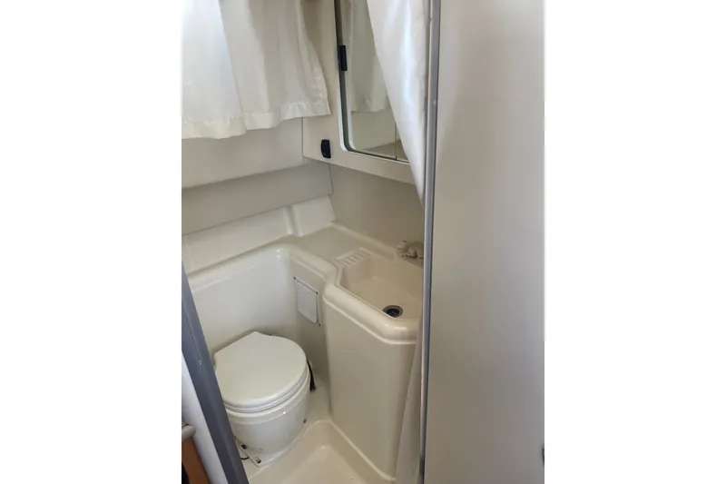 Slide: The Image of Compact bathroom in 2007 Bayliner Discovery 288 boat, featuring toilet and sink. - 8