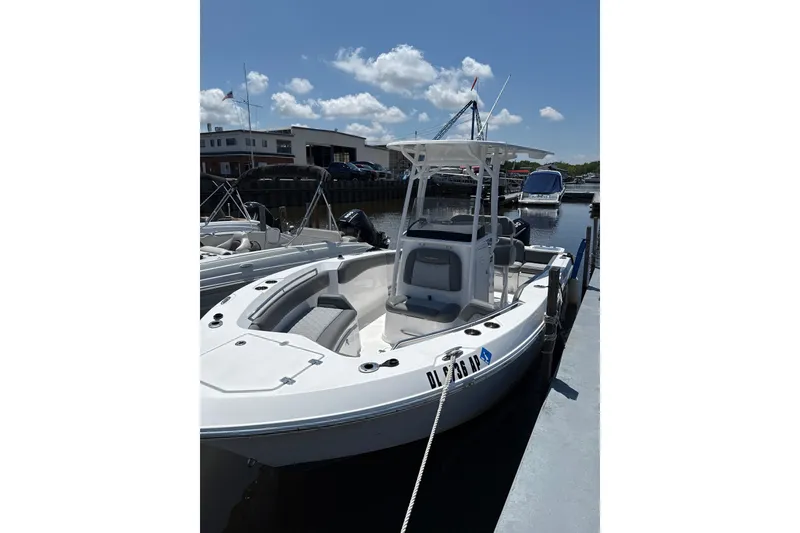 The Image of 2024 NauticStar 222L Offshore boat docked under a clear blue sky. - 0