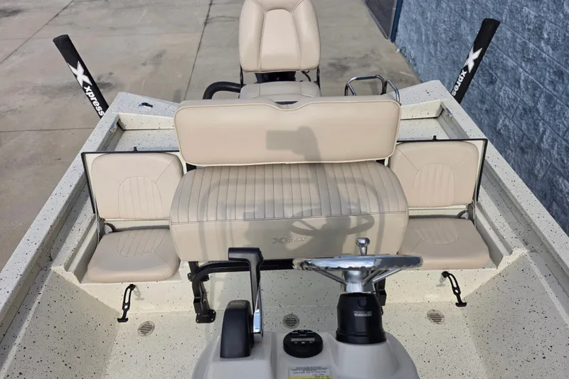 Slide: The Image of 2014 Xpress H22 Bay boat interior with beige seating and steering wheel. - 10
