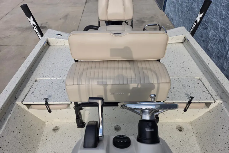 Slide: The Image of 2014 Xpress H22 Bay boat interior with beige seating and steering console. - 11