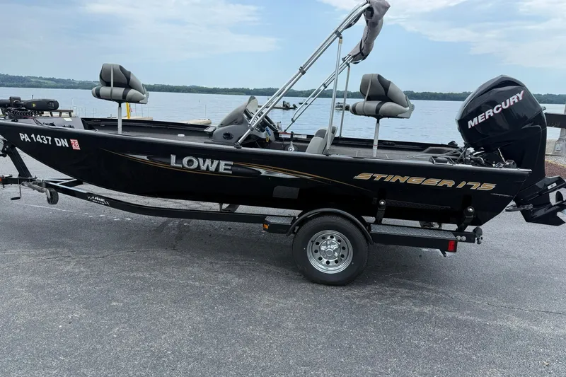 Slide: The Image of 2014 Lowe Stinger 175 boat with Mercury engine on trailer by a lake. - 2