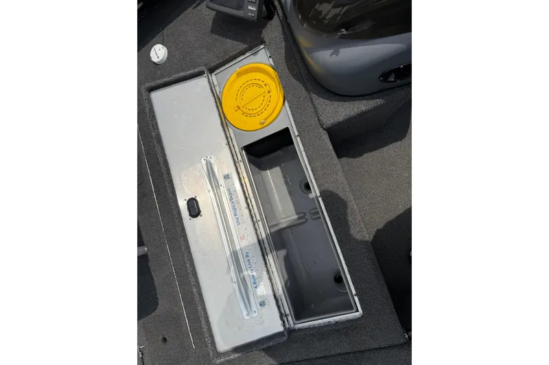 Slide: The Image of 2014 Lowe Stinger 175 boat storage compartment with yellow lid and measuring ruler. - 17