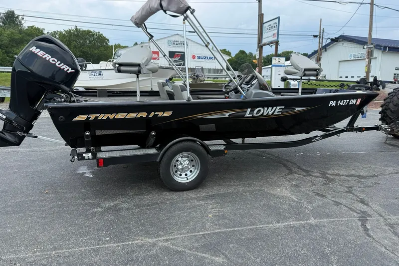 Slide: The Image of 2014 Lowe Stinger 175 boat with Mercury engine on trailer, parked outdoors. - 6