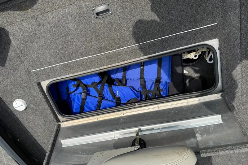 Slide: The Image of Storage compartment in a 2014 Lowe Stinger 175 boat with blue life jackets. - 18