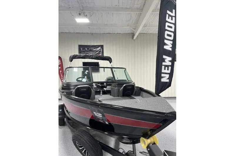 The Image of 2027 Lund 1875 Impact XS boat displayed indoors with "New Model" banner. - 0