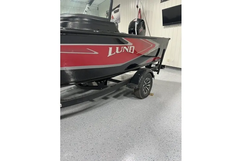 Slide: The Image of 2027 Lund 1875 Impact XS boat on trailer in showroom. - 2