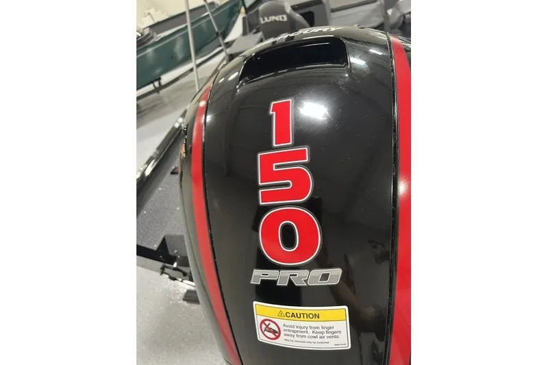 Slide: The Image of 2027 Lund 1875 Impact XS boat with 150 Pro engine, caution label visible. - 16