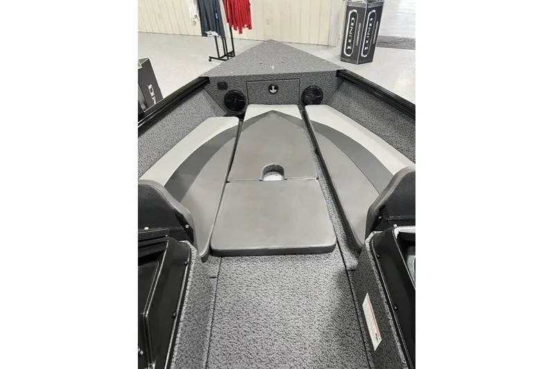 Slide: The Image of 2027 Lund 1875 Impact XS boat interior with gray seating and carpeted flooring. - 6