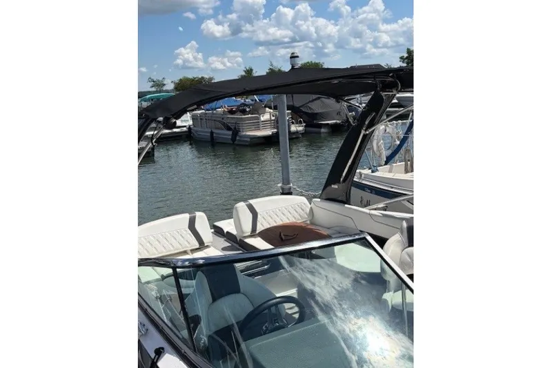 Slide: The Image of 2018 Regal 2300 Bowrider boat docked at marina under a sunny sky. - 12