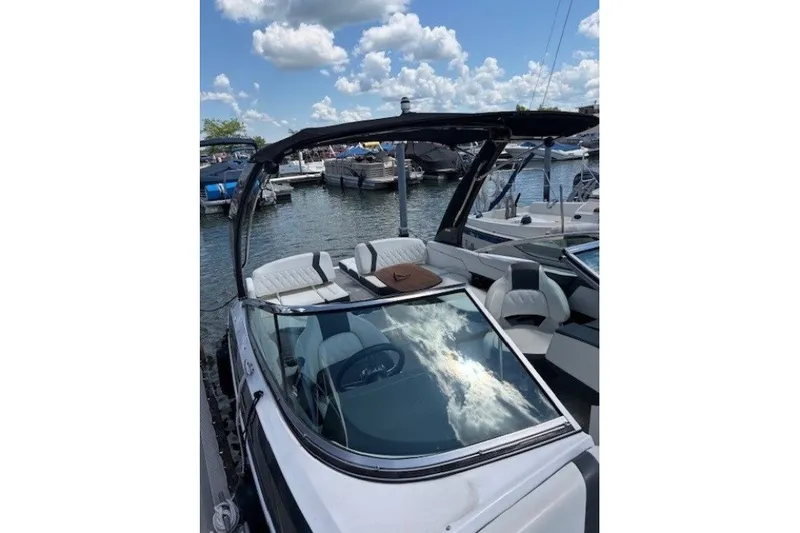 Slide: The Image of 2018 Regal 2300 Bowrider boat docked at marina under blue sky. - 5