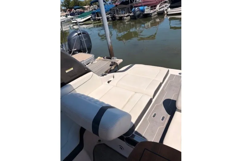 Slide: The Image of 2018 Regal 2300 Bowrider boat interior with white seating at marina. - 11