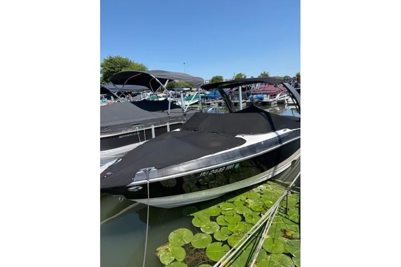 Slide: The Image of 2018 Regal 2300 Bowrider boat docked, covered, surrounded by lily pads. - 3