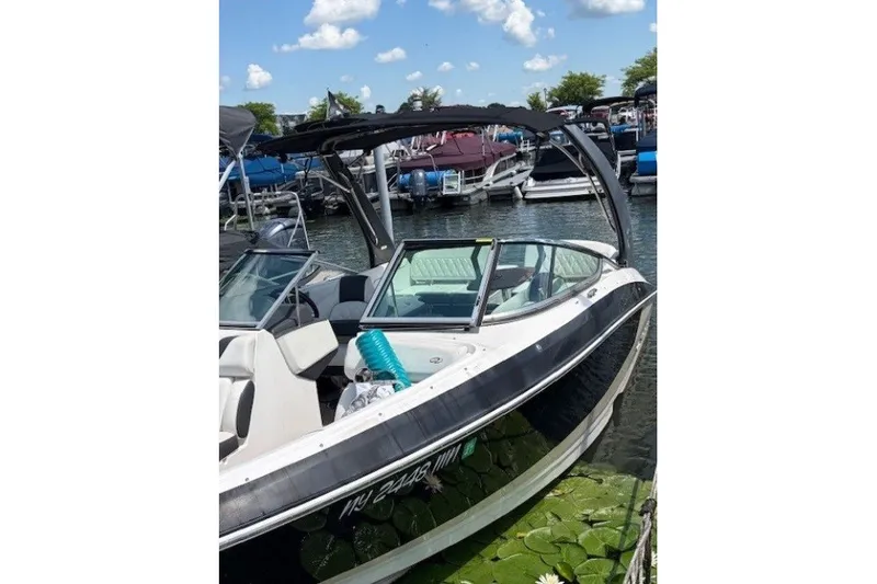 Slide: The Image of 2018 Regal 2300 Bowrider boat docked at marina under clear blue sky. - 4