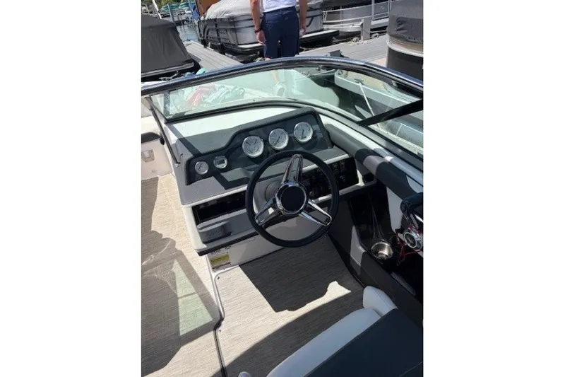 Slide: The Image of 2018 Regal 2300 Bowrider dashboard with steering wheel and gauges, docked at marina. - 6