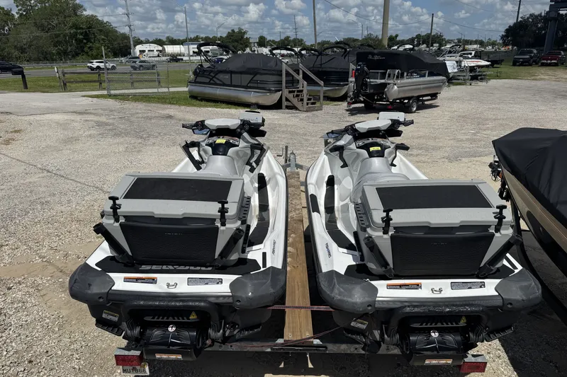 The Image of Two 2022 Sea-Doo FishPro Scout 130 jet skis parked on a gravel lot. - 1