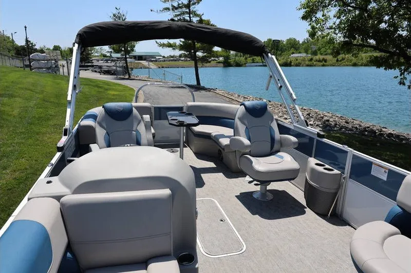 Slide: The Image of 2025 South Bay 220 RS LE 2.75 pontoon boat interior by a scenic lake. - 9