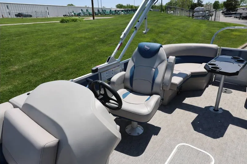 Slide: The Image of 2025 South Bay 220 RS LE 2.75 pontoon boat interior with captain's chair and seating area. - 12