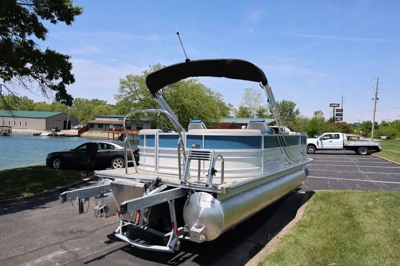 Slide: The Image of 2025 South Bay 220 RS LE 2.75 pontoon boat parked near a lake. - 8