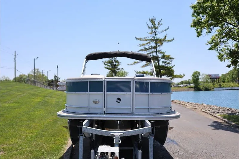 Slide: The Image of 2025 South Bay 220 RS LE 2.75 pontoon boat on trailer by a lake. - 3