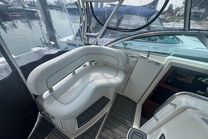 Slide: The Image of 2005 Wellcraft 290 Coastal boat interior with white seating and marina view. - 8