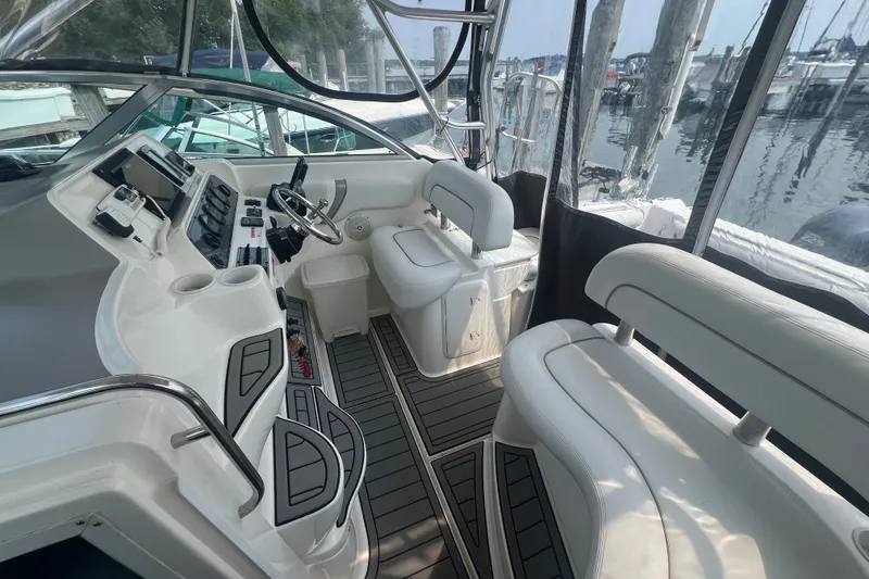 Slide: The Image of 2005 Wellcraft 290 Coastal boat interior with helm, seating, and controls at marina. - 6