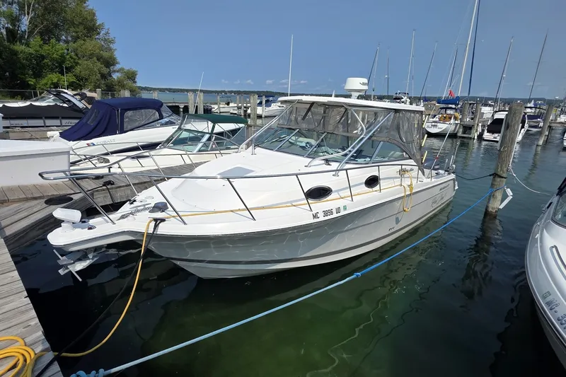 Slide: The Image of 2005 Wellcraft 290 Coastal boat docked in a marina, surrounded by other vessels. - 1