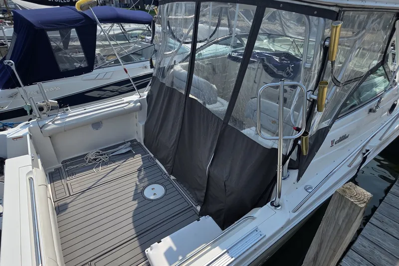 Slide: The Image of 2005 Wellcraft 290 Coastal boat docked, featuring spacious deck and protective canopy. - 7