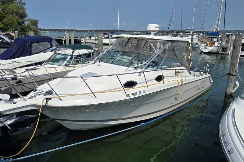 The Image of 2005 Wellcraft 290 Coastal boat docked at a marina, surrounded by other vessels. - 0