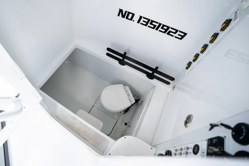 Slide: The Image of Interior of 2025 Contender 39 ST boat, featuring a compact marine toilet. - 54