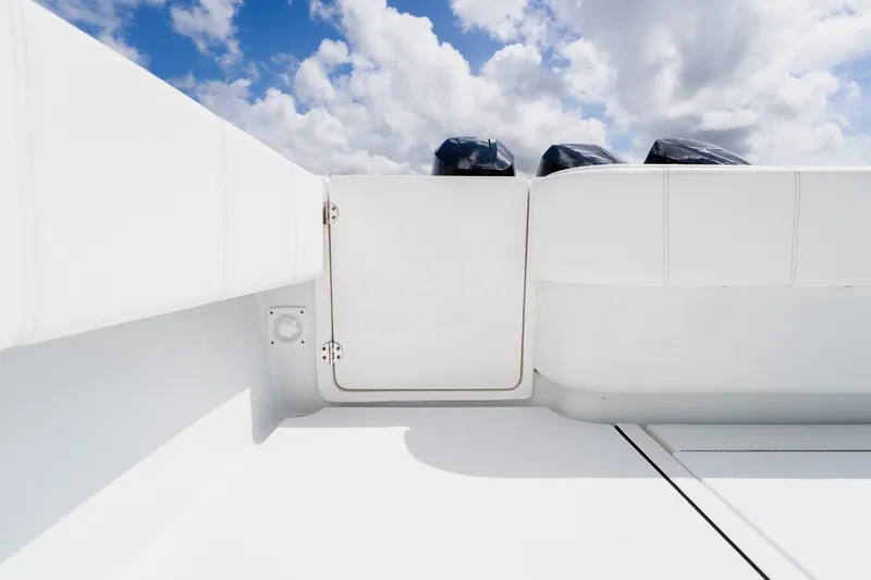 Slide: The Image of 2025 Contender 39 ST boat interior with white seating and blue sky background. - 52
