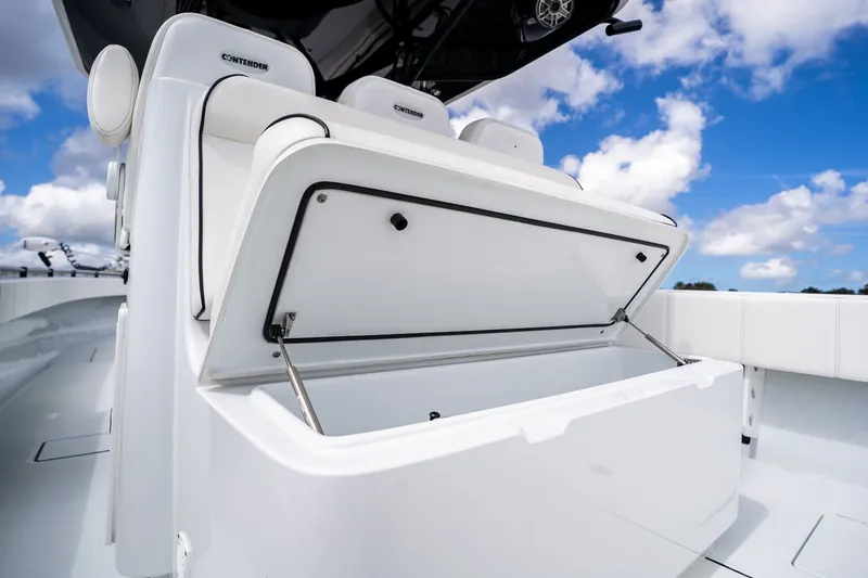 Slide: The Image of 2025 Contender 39 ST boat with open storage compartment under blue sky. - 41