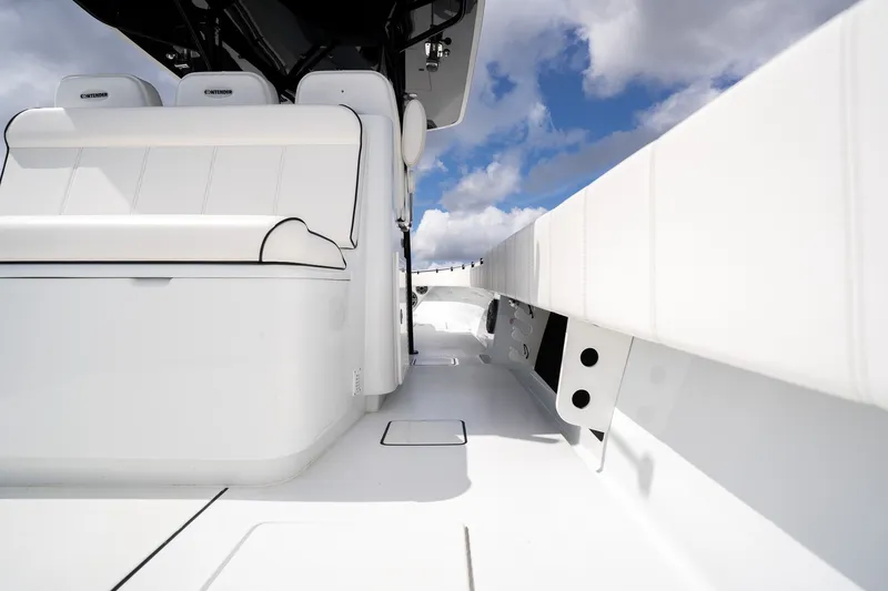 Slide: The Image of 2025 Contender 39 ST boat interior with white seating and sleek design under blue sky. - 39