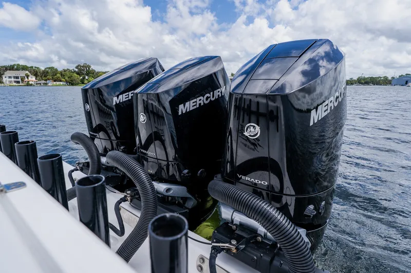 Slide: The Image of Triple Mercury Verado engines on a 2025 Contender 39 ST boat, cruising on a lake. - 50