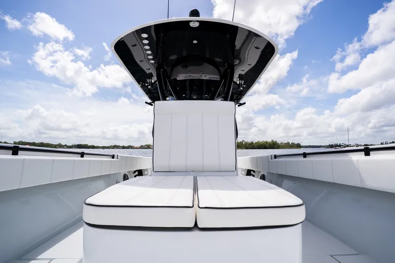 Slide: The Image of 2025 Contender 39 ST boat interior with white seating under a blue sky. - 21
