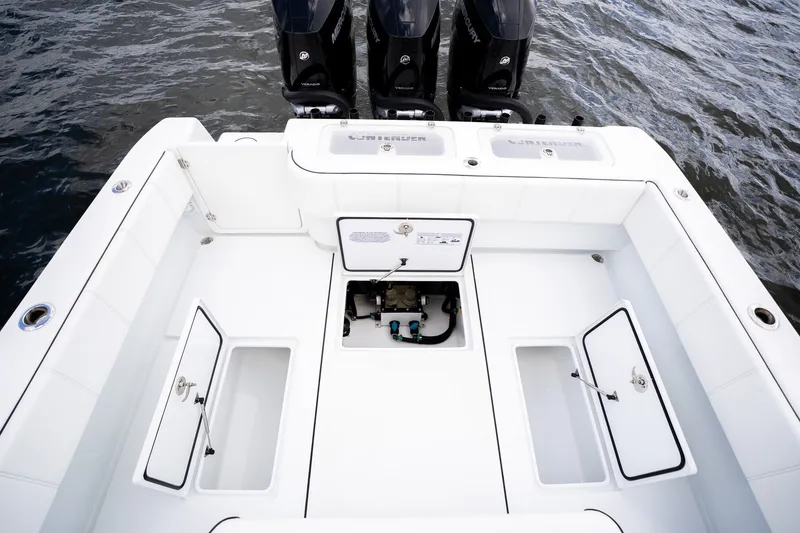 Slide: The Image of 2025 Contender 39 ST boat deck with storage compartments and triple Mercury engines. - 44