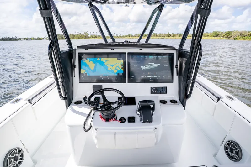 Slide: The Image of 2025 Contender 39 ST boat cockpit with dual navigation screens and steering wheel. - 31
