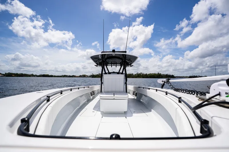 Slide: The Image of 2025 Contender 39 ST boat on water under blue sky with clouds. - 20