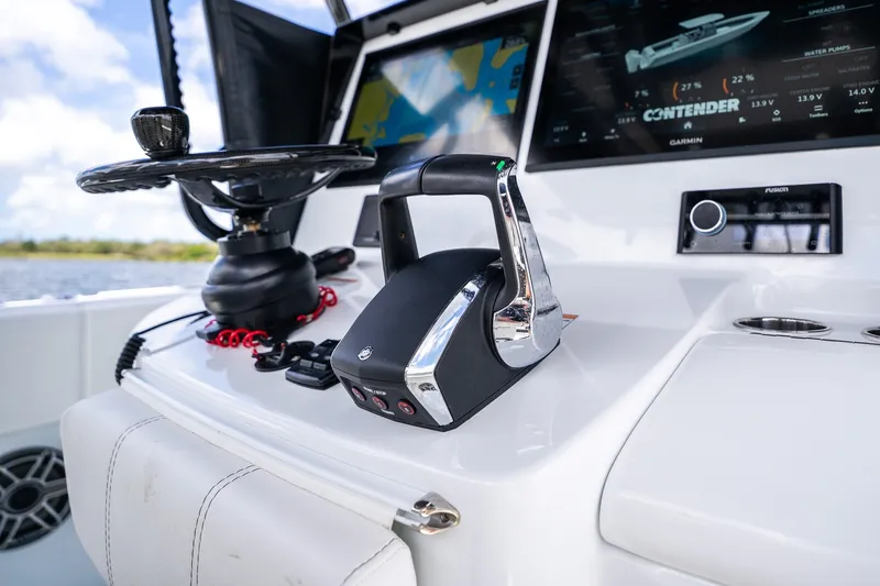 Slide: The Image of Control panel of 2025 Contender 39 ST boat with steering wheel and digital display. - 33