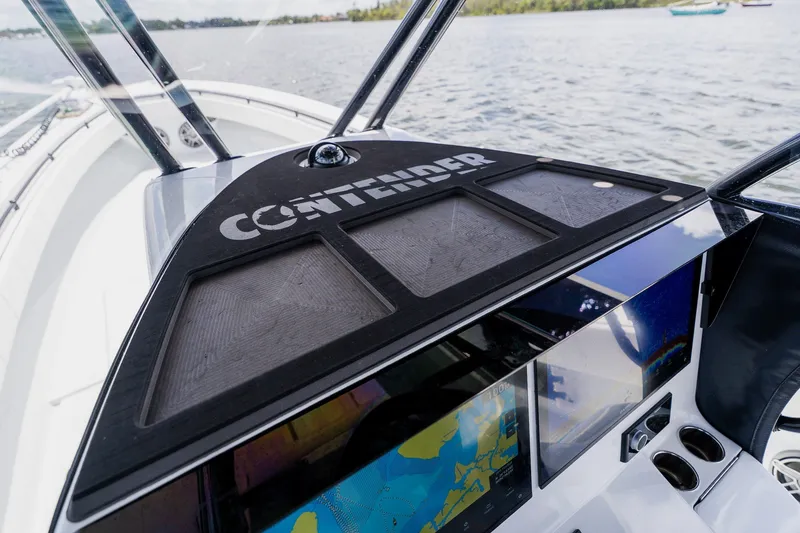 Slide: The Image of 2025 Contender 39 ST boat dashboard with navigation screens on open water. - 35