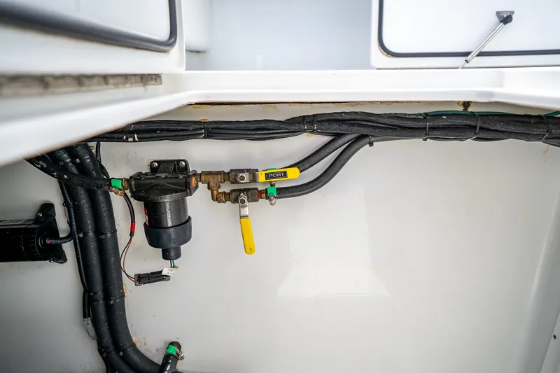 Slide: The Image of 2025 Contender 39 ST boat plumbing system with valves and hoses. - 58