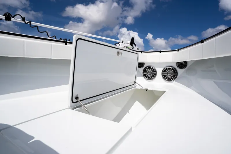 Slide: The Image of 2025 Contender 39 ST boat interior with open storage compartment and speakers under blue sky. - 18