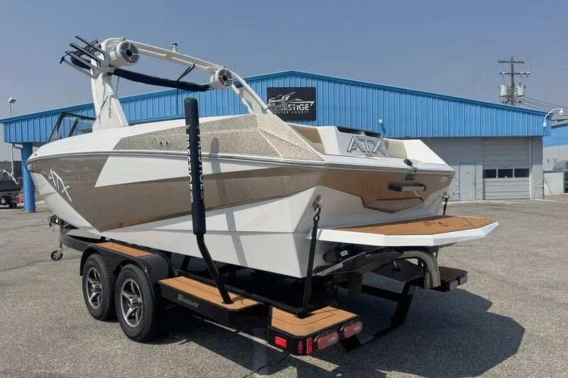 Slide: The Image of 2021 ATX Surf Boats 24 Type-S on trailer, parked outside blue building. - 17