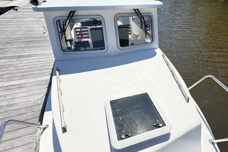 Slide: The Image of 2020 Seaway 24 boat docked by the water, showcasing cabin and deck details. - 29