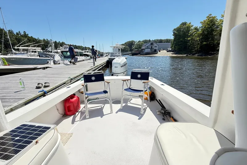 Slide: The Image of 2020 Seaway 24 boat docked, featuring chairs and Honda outboard motor. - 26