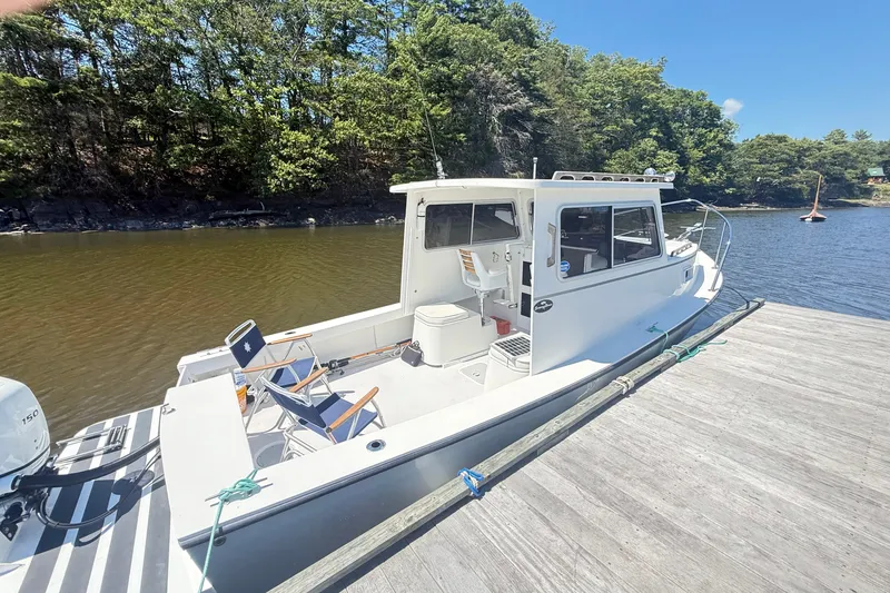 Slide: The Image of 2020 Seaway 24 boat docked by a scenic lakeside with lush trees. - 35